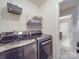 Well-lit laundry room featuring modern washer and dryer, plus shelving, for convenient home maintenance at 2037 Christopher Wood Ct, Indian Land, SC 29707
