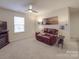 Spacious living room offers leather couch, ceiling fan, and wall art, with a warm and inviting atmosphere at 2037 Christopher Wood Ct, Indian Land, SC 29707