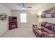 Comfortable living room featuring a ceiling fan, leather sofa, and a warm ambiance, perfect for relaxation and entertainment at 2037 Christopher Wood Ct, Indian Land, SC 29707