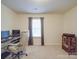 Functional office space with desk, computer, rolling chair, large window and neutral carpet floors at 2037 Christopher Wood Ct, Indian Land, SC 29707