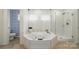Bright bathroom featuring a large soaking tub, glass-enclosed shower, and stylish tiling at 21300 Crown Lake Dr, Cornelius, NC 28031