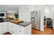 Modern kitchen featuring black countertops, stainless steel refrigerator, and white cabinets and island at 21300 Crown Lake Dr, Cornelius, NC 28031