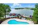 Resort-style community pool with lounge chairs, a nearby marina, and stunning lake views from the pool deck at 21300 Crown Lake Dr, Cornelius, NC 28031