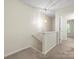 Carpeted hallway with carpeted staircase and a light fixture on the second floor at 2137 Midnight Blue Ln, Fort Mill, SC 29708
