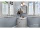 Charming bathroom with updated fixtures, a white vanity, and a framed mirror in a bright, windowed space at 218 5Th Se St, Hickory, NC 28602