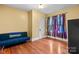 Cozy bedroom with yellow walls, hardwood floors, and a bright window with unique, colorful curtains at 218 5Th Se St, Hickory, NC 28602