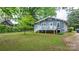 Charming blue home featuring a white porch, set on a lush green lawn and mature trees at 218 5Th Se St, Hickory, NC 28602