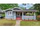 Charming home with a welcoming front porch, red stairs, green grass, and blue accents at 218 5Th Se St, Hickory, NC 28602