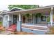 Inviting front porch with swing, hanging plants, and a red staircase at 218 5Th Se St, Hickory, NC 28602