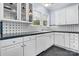 Well-lit kitchen features white cabinetry, tiled backsplash, and black countertops at 218 5Th Se St, Hickory, NC 28602