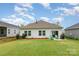 Grassy backyard featuring a white siding and a patio with green outdoor seating at 2202 Cherrybark Ct, Denver, NC 28037