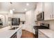 Well-lit modern kitchen with white cabinets, stainless steel appliances, and sleek countertops at 2202 Cherrybark Ct, Denver, NC 28037