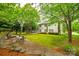 A charming backyard featuring a stone patio, fire pit, and lush landscaping, ideal for entertaining at 2235 Legacy Oak Dr, Waxhaw, NC 28173