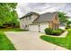 Home's exterior featuring a spacious driveway, two-car garage, and partial brick facade at 2235 Legacy Oak Dr, Waxhaw, NC 28173