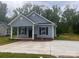 Inviting single-story home with a classic design, covered porch, and a spacious concrete driveway at 225 Baker St, Rock Hill, SC 29730