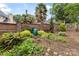 Serene backyard featuring lush garden beds, a brick wall, and mature trees at 310 Whitestone Rd, Charlotte, NC 28270