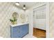 Bright bathroom featuring dual gold framed mirrors, blue vanity with white countertops and access to the closet at 310 Whitestone Rd, Charlotte, NC 28270