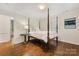 Bedroom with a wooden four poster bed, hardwood floors, and a window with natural light at 310 Whitestone Rd, Charlotte, NC 28270
