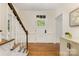 Welcoming foyer featuring hardwood floors, a staircase with white trim, and a classic front door with glass panels at 310 Whitestone Rd, Charlotte, NC 28270