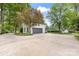 Spacious two-car garage and a driveway, surrounded by mature trees at 310 Whitestone Rd, Charlotte, NC 28270