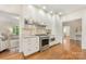 Modern kitchen with white cabinets, stainless steel appliances, hardwood floors and seamless transition to sunroom at 310 Whitestone Rd, Charlotte, NC 28270