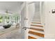 Bright staircase boasts wood treads, white risers, and a view to a sunroom at 310 Whitestone Rd, Charlotte, NC 28270
