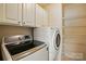 A well-lit laundry room with a washer, dryer, and white cabinets at 3327 Flagler Cir, Midland, NC 28107