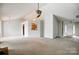 Open-concept living room features a large window, ceiling fan, and a view into the adjacent kitchen at 3327 Flagler Cir, Midland, NC 28107