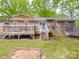 Brick home featuring a large deck with patio furniture, a sandbox and a trampoline for outdoor activities at 335 Linda St, Salisbury, NC 28146