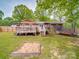 Brick home featuring a large deck with patio furniture, a sandbox and a trampoline for outdoor activities at 335 Linda St, Salisbury, NC 28146