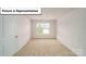 Bedroom featuring neutral carpeting, a window, and a white door at 3412 Lacebark Ln, Gastonia, NC 28056