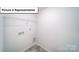 Functional laundry room with utility connections and overhead shelving for storage and organization at 3412 Lacebark Ln, Gastonia, NC 28056