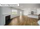 Open-concept living room featuring a fireplace, hardwood floors, and a modern kitchen at 3412 Lacebark Ln, Gastonia, NC 28056