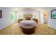 Well-lit bedroom with neutral decor, a tufted headboard, and a cozy seating area at 3414 Lacebark Ln, Gastonia, NC 28056