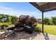 Outdoor patio with a built-in firepit, grill, and mature landscaping at 3424 Windstone Ln, Gastonia, NC 28056