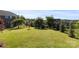 View of a large backyard with mature trees and lawn with a black metal fence at 3424 Windstone Ln, Gastonia, NC 28056
