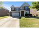Charming two-story home featuring a well-maintained lawn, brick accents, and a two-car garage, offering curb appeal at 3424 Windstone Ln, Gastonia, NC 28056