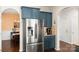 Modern kitchen featuring stainless steel refrigerator, stylish blue cabinets, and granite countertops at 3424 Windstone Ln, Gastonia, NC 28056