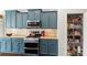 Stylish kitchen features blue cabinets, stainless steel appliances, granite counters and an open pantry at 3424 Windstone Ln, Gastonia, NC 28056