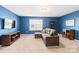 Living room featuring blue accent wall, plush sofa and mounted television at 3424 Windstone Ln, Gastonia, NC 28056
