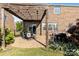 View of a brick patio with dining and grill under a wood pergola and adjacent landscaping at 3424 Windstone Ln, Gastonia, NC 28056