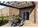 View of a brick patio with dining under a wood pergola and adjacent landscaping at 3424 Windstone Ln, Gastonia, NC 28056