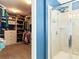 Tiled shower next to walk-in closet with custom shelving and organized storage at 3424 Windstone Ln, Gastonia, NC 28056