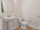 Clean, modern bathroom with pedestal sink, toilet, and neutral decor at 355 S Bruns Ave, Charlotte, NC 28208