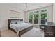 Primary bedroom with a large window, neutral colors, carpeted floor, and a stylish ceiling fan at 355 S Bruns Ave, Charlotte, NC 28208