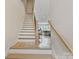 Bright staircase with wood handrail and treads, leading to the open living space, with kitchen in background at 355 S Bruns Ave, Charlotte, NC 28208