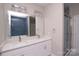 Modern bathroom featuring double sinks, a large mirror, and stylish blue tiled shower and tub at 4006 Scarlet Dr # 29, Matthews, NC 28104