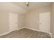 A neutral bedroom featuring two white paneled doors and modern gray wood-look flooring at 4006 Scarlet Dr # 29, Matthews, NC 28104