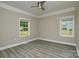 A cozy bedroom with two windows, neutral walls, and stylish gray flooring at 4006 Scarlet Dr # 29, Matthews, NC 28104