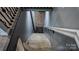 A well-lit staircase with neutral colors, features a striking rug at the bottom, enhancing the home's interior at 403 3Rd Nw St, Conover, NC 28613